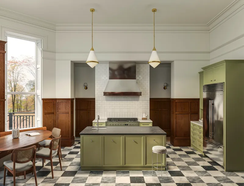 Kitchen with green cabinetry, checkerboard floor and brass pendants